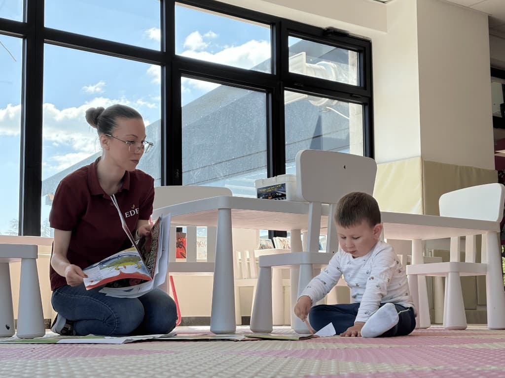 Radnica u EDEN-u čita deci knjigu u igraonici